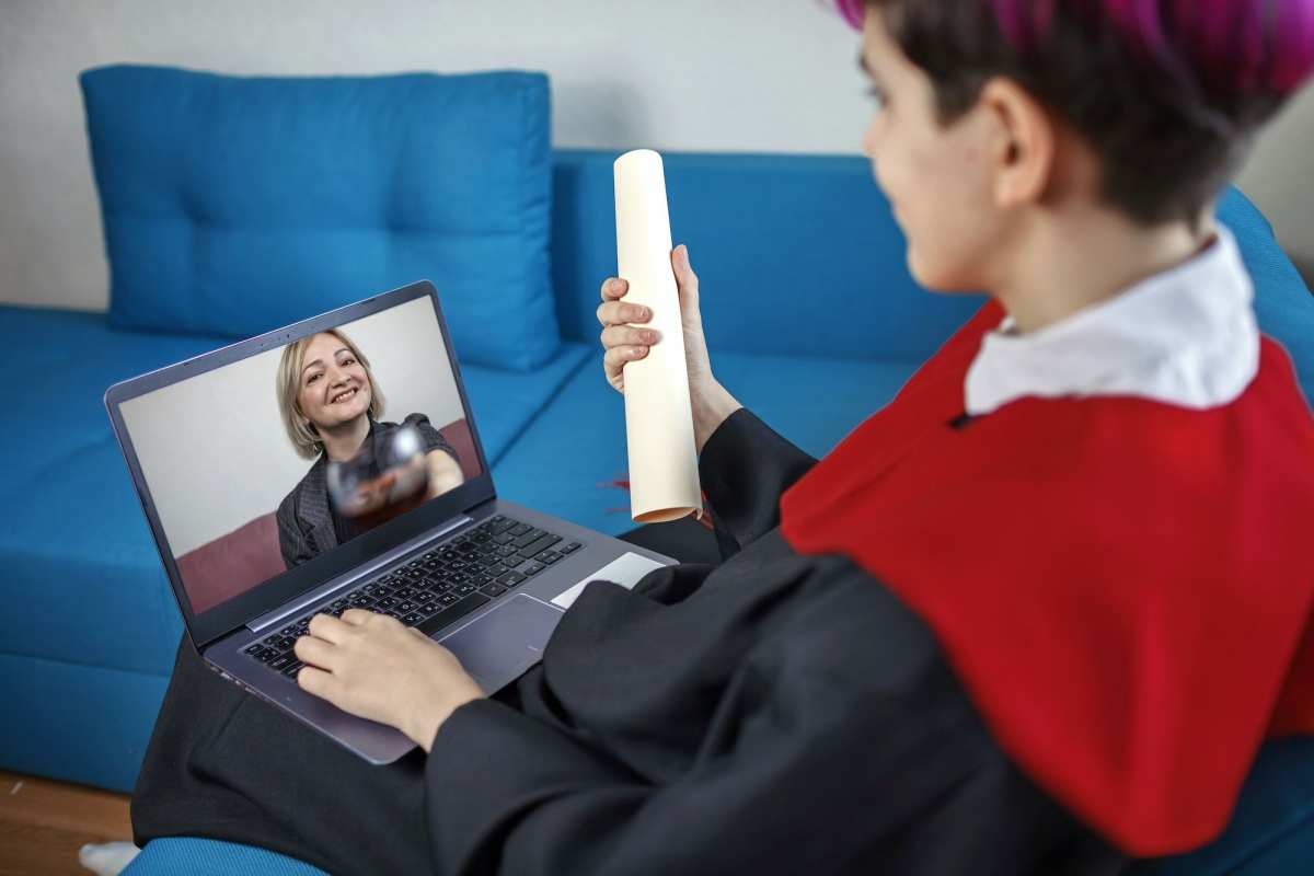 Ceremonia de graduación virtual. Estudiante recibiendo felicitaciones de su madre durante una videollamada en línea