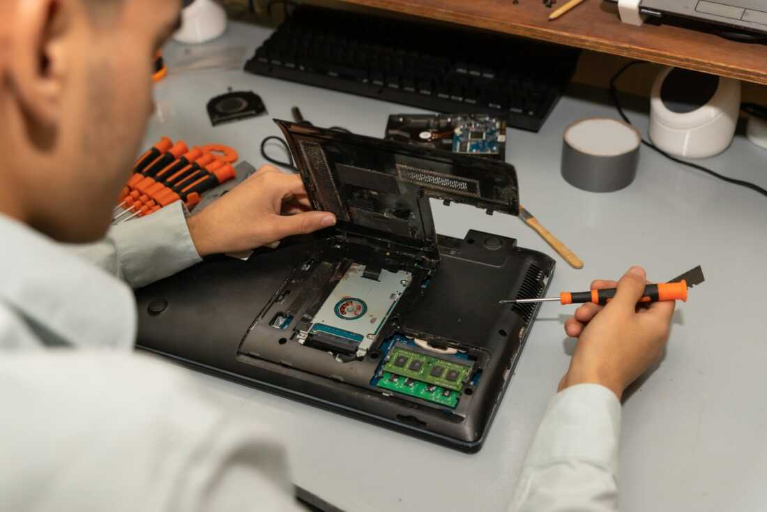 Computer repair technician repairing a laptop