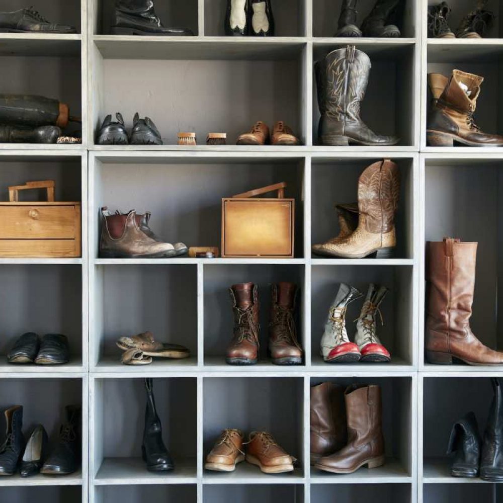 Exhibición de botas y zapatos en los estantes de la tienda online